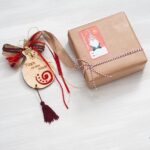 Ξύλινο ρόδι σε κρεμαστό Χριστουγεννιάτικο γούρι με κόκκινες κορδέλες